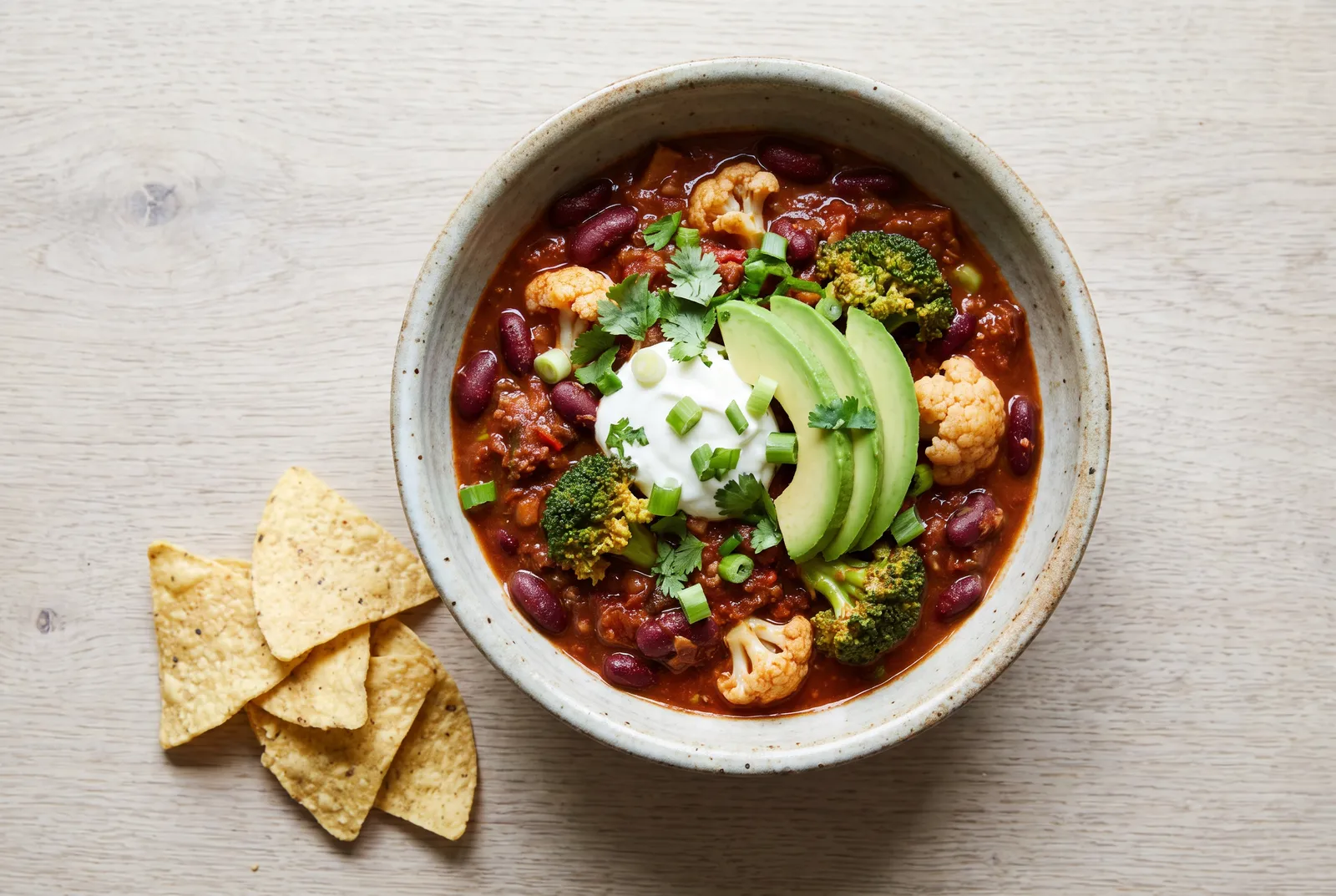 Chili con carne with broccoli, cauliflower, sour cream and avocado